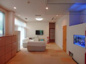 uma sala de estar com um sofá e uma televisão em Sabi Katayama - Vacation STAY 56437v em Kaiyo