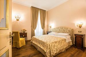 a hotel room with a bed and a chair at Frezza Apartment - Alta Luxury Apartments in Rome