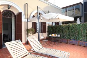 2 stoelen en een parasol op een patio bij Villa Pirandello in Rome