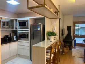 a kitchen with a stainless steel refrigerator and a counter at APTO Novo no Coração de Gramado in Gramado