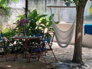 a table and chairs and a hammock in a garden at Casa "La 44" in Mérida