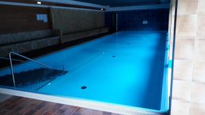 a large swimming pool with blue water at Haus Enzian - Apartment Gerlitzen in Kanzelhöhe
