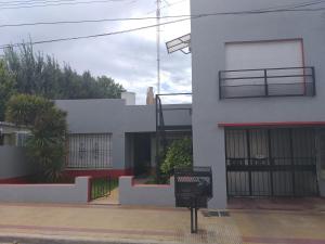 Edificio blanco con puerta y balcón en Apartamento El Calvario 3, en Tandil
