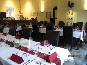 un comedor con mesas con servilletas y sillas rojas en Juffer Flair Restaurant Gästehaus en Brauneberg