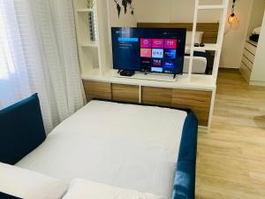 uma sala de estar com uma cama e uma televisão de ecrã plano em Studio Inteiro 84a ( Morumbi) em São Paulo