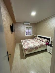 a bedroom with a bed and a window at Location appartement Alhoceima in Al Hoceïma