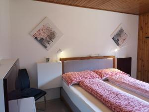 1 dormitorio con 1 cama y TV. en Aletschblick, en Grächen