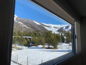 a window with a view of a snow covered mountain at CATEDRAL SUITES in San Carlos de Bariloche