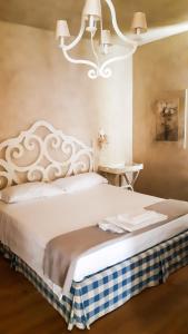 Farra di SoligoにあるCasa Marinelliのベッドルーム(シャンデリア付きの白い大型ベッド1台付)