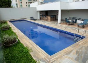 uma piscina com água azul num edifício em Gran Executive Hotel em Uberlândia