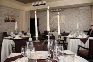a dining room with tables and chairs with candles at Enigma Pension in Târgu Jiu