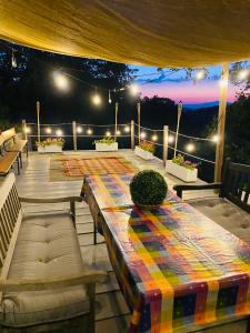 a patio with a table and benches and lights at Villa Edera in San Venanzo