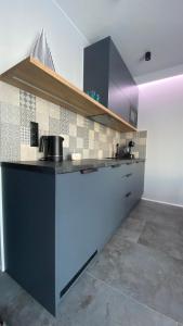a kitchen with a blue counter top in a room at Apartament MAGMA z basenem Morska Klifowa Rewal - blisko HOSSOLAND in Rewal