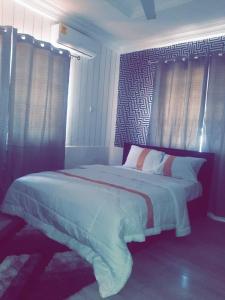 MAXJEN HAVEN GUEST HOUSE في Kasoa: غرفة نوم بسرير كبير في غرفة