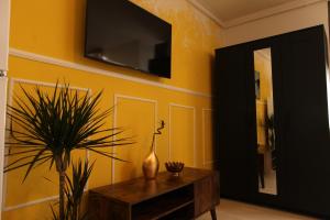 a living room with a table and a tv on a wall at Studio „Pompei” Brasov in Braşov