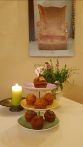 a three tiered plate of muffins on a table with a candle at Casa Marinelli in Farra di Soligo