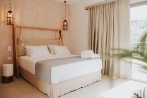 a bedroom with a large bed with white pillows at elia boutique hotel in Parga