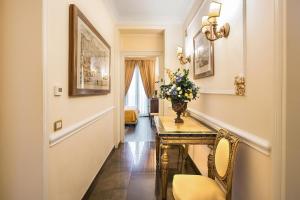 Oca Apartment - Alta Luxury Apartments في روما: ممر به طاولة عليها إناء من الزهور