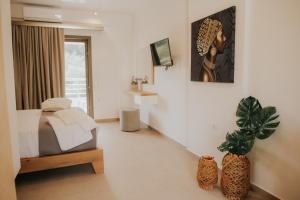 a bedroom with a bed and a potted plant at elia boutique hotel in Parga