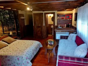 a bedroom with a bed and a couch and a table at Ranch pod lesom Slovensky Raj in Spišský Štiavnik