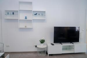 a living room with a tv and a white wall at high class flat in Luxembourg