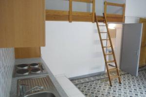 a kitchen with a ladder and a sink and a refrigerator at Studio Mezzanine au cœur de Saint Marcellin in Saint-Marcellin