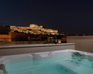 una vasca da bagno con vista sull'acropoli di notte di THIRAMENOUS RESIDENCE ad Atene