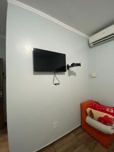 a flat screen tv hanging on a white wall at Hotel Calema in Capitão Leônidas Marques
