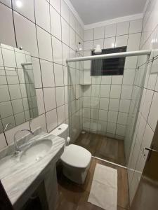 a white bathroom with a toilet and a sink at Hotel Calema in Capitão Leônidas Marques