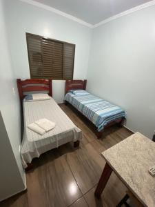 um quarto com duas camas e uma mesa em Hotel Calema em Capitão Leônidas Marques