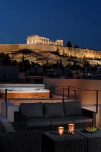 un divano posto sopra un balcone con un edificio di THIRAMENOUS RESIDENCE ad Atene