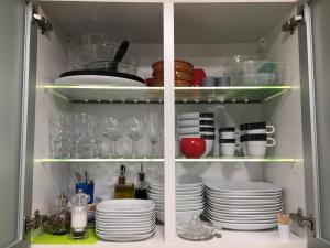 un armadio pieno di piatti, bicchieri e piatti di Lovely Studio Cannes a Cannes