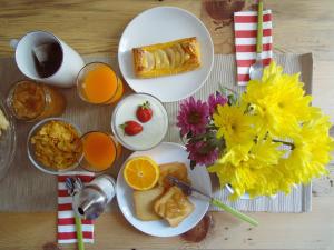 a table topped with plates of breakfast foods and orange juice at Serafino B&B in Palermo