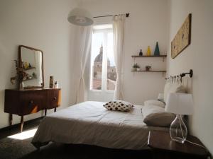 1 dormitorio con cama con espejo y ventana en Serafino B&B, en Palermo