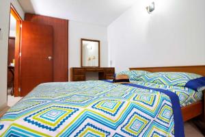 1 dormitorio con 1 cama con un edredón colorido en Apartamento - 3 Dormitorios en el Rodadero ツ en Puerto de Gaira