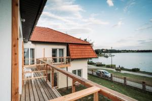 a house with a deck with a view of the water at Willa Z Widokiem na Jezioro in Ryn