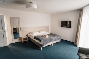 1 dormitorio con 1 cama con sombrero en Willa Z Widokiem na Jezioro, en Ryn