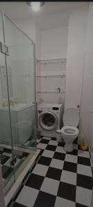 a bathroom with a toilet and a checkered floor at Centre Apartment Old Tbilisi in Tbilisi City