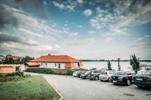 a row of cars parked in a parking lot next to a lake at Willa Z Widokiem na Jezioro in Ryn