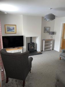 sala de estar con TV y silla en The Clara, Ballycastle, en Ballycastle