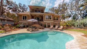 a house with a swimming pool in front of a house at 5 Rum Row in Hilton Head Island
