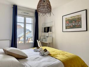 a bedroom with a bed with two pillows on it at L'ancre Marine YourHostHelper in Deauville