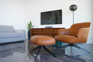 a living room with two chairs and a tv at New&Luxury Apartment with an Outstanding View - Bombii Blue in Dubrovnik