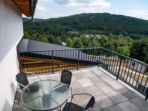 鲁哈科维斯Wellness Apartmány Panorama的屋顶上有一张桌子和几把椅子的阳台