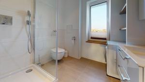 a bathroom with a shower and a toilet and a window at Lieblingsapartment No.08 mit Blick auf den Rostocker Stadthafen in Rostock