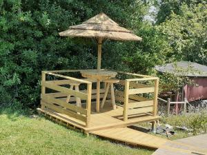 a wooden table with an umbrella on a deck at Les Mandarins in Baladou