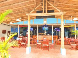 una zona de comedor con mesas y sillas en un restaurante en Fish Hook Marina Hotel, en Golfito