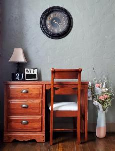 a desk with a chair and a clock on the wall at Guest Apartment at Commercial Street Studio in Lebanon
