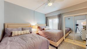 a bedroom with two beds and a mirror at 240 Captains Quarters in Hilton Head Island