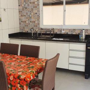 a kitchen with a table with chairs and a sink at Casa com Piscina na Riviera São Lourenço - módulo 24 in Riviera de São Lourenço